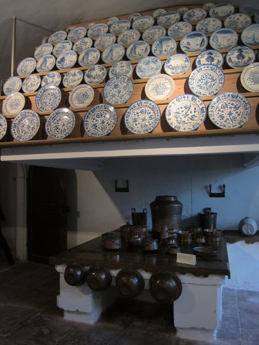 Des assiettes en porcelaine présentées dans l'énorme cuisine du château.