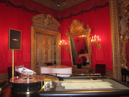 Tables de jeux et piano blanc dans le Salon Rouge.