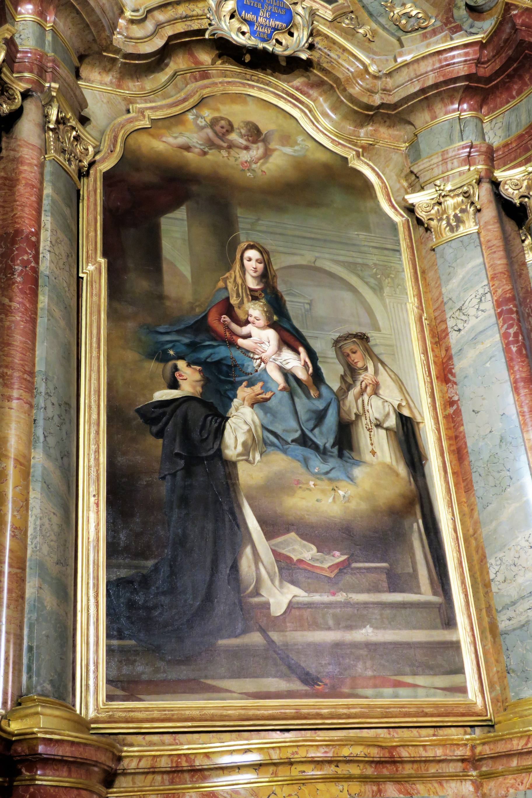 Le tableua de l'autel latéral gauche est une oeuvre de Georg Kau, de 1902 et représente Notre-Dame du Saint-Rosaire. La Vierge tient sur ses genoux l'Enfant Jésus qui remet un rosaire à Saint Dominique alors qu'à droite sainte Catherine prie le chapelet.
