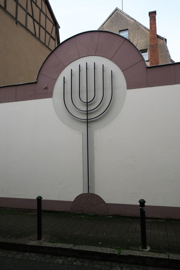 Une menorah, le chandelier à 7 branches, orne le mur d'enceinte de la synagogue.
